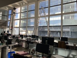 Office space with a man on a lift reaching the top windows.