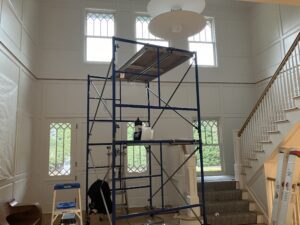 Scaffolding in front of a two-story foyer with a staircase.